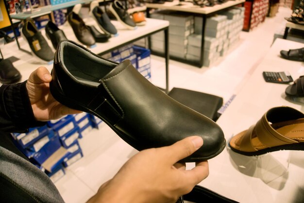 Foto hombre eligiendo zapatos de cuero en un centro comercial