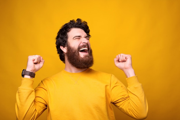 El hombre emocionado está haciendo el gesto ganador gritando carga de alegría.