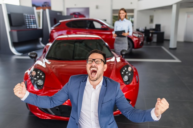 Foto hombre emocionado feliz por la compra de un coche nuevo.