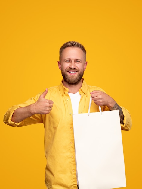 Hombre emocionado mostrando el pulgar hacia arriba para una compra exitosa