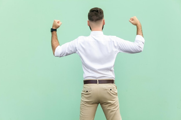 Hombre emocional en camisa blanca cerca de fondo verde