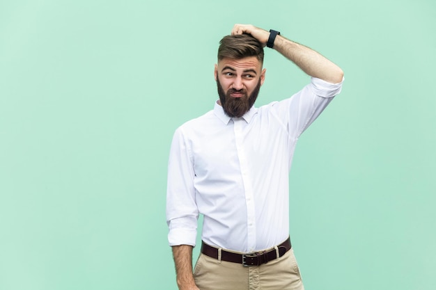 Hombre emocional en camisa blanca cerca de fondo verde