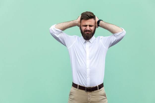 Hombre emocional en camisa blanca cerca de fondo verde