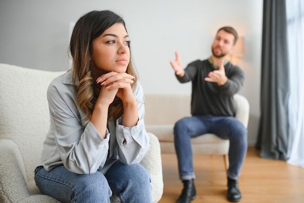 Hombre emocional gesticulando y gritando a su esposa pareja joven que tiene una pelea en casa concepto de abuso doméstico