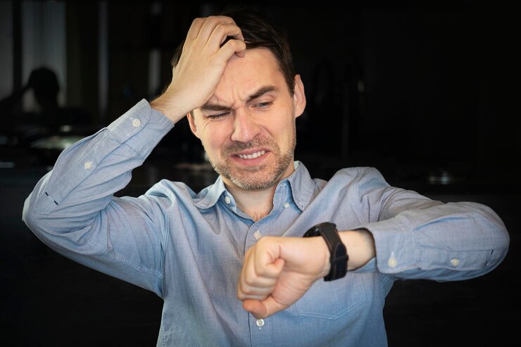 Foto hombre emocional revisando el tiempo en el fondo negro llegar tarde concepto el concepto de llegar tarde al trabajo rompiendo los plazos en los negocios un plazo difícil