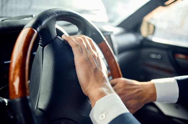 Hombre emocional en un traje en un coche, un viaje al éxito laboral