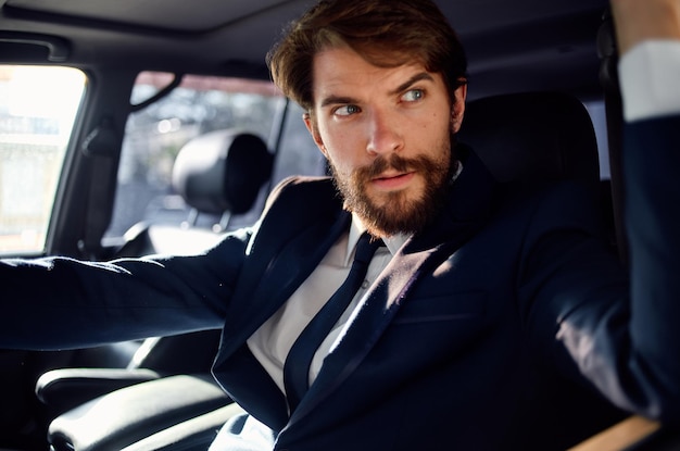 Hombre emocional en traje en un coche un viaje al trabajo confianza en sí mismo foto de alta calidad