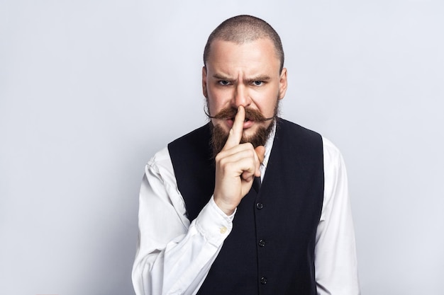 Hombre emocional en traje sobre fondo gris