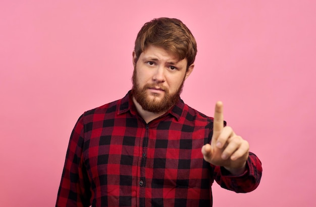 Hombre con emociones en la cara con barba en un espacio de copia de logotipo de fondo rosa