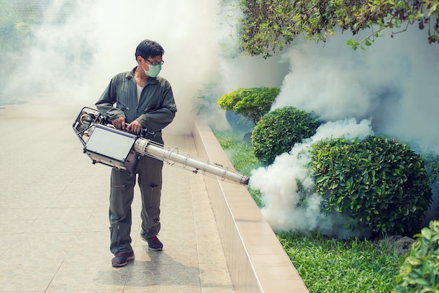 El hombre se empaña para eliminar el mosquito para prevenir la propagación de la fiebre del dengue y el virus zika