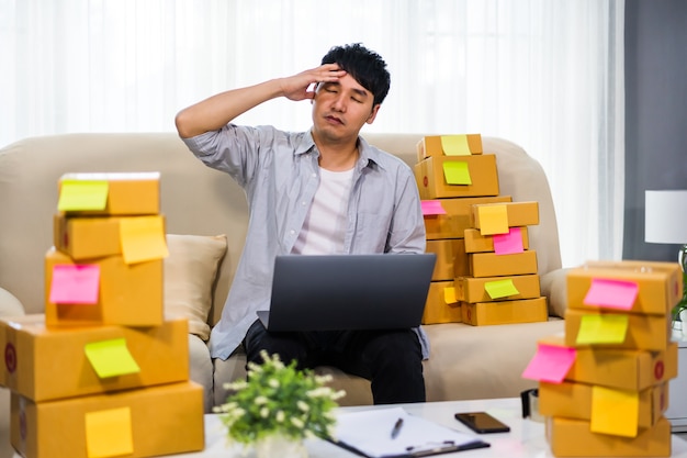 Hombre emprendedor estresado que trabaja con una computadora portátil y tiene problemas para vender productos en línea en la oficina en casa