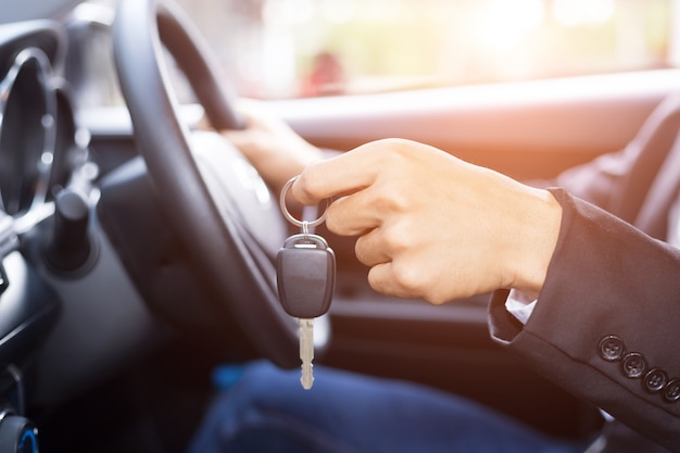 Hombre empresario adulto en un traje y sosteniendo una llave de coche en su mano