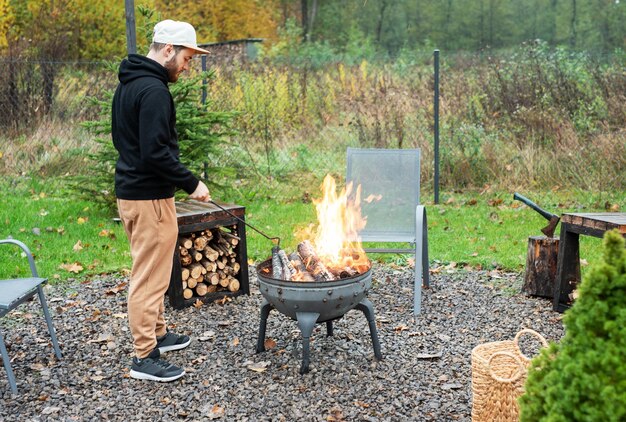 Un hombre enciende una barbacoa en la naturaleza