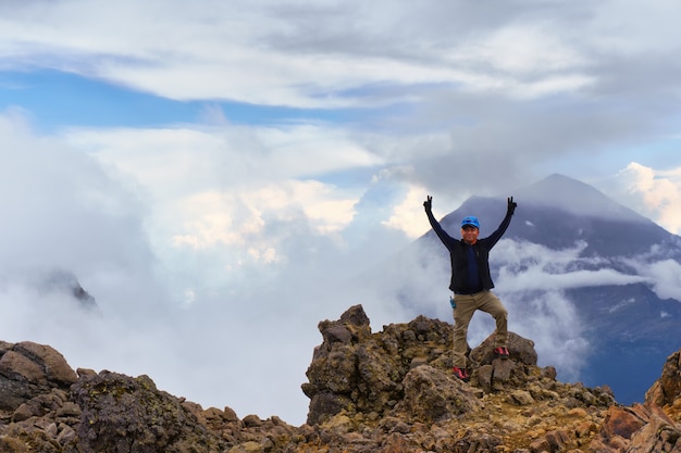 El hombre se encuentra en el borde de un acantilado con un hermoso cielo con el volcán Popocatépetl de fondo