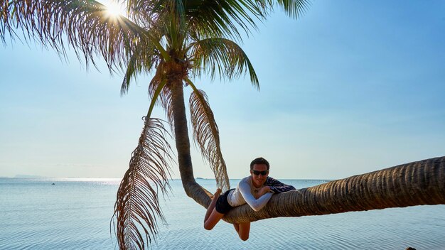 El hombre se encuentra en la palma. Koh Pangan. Tailandia