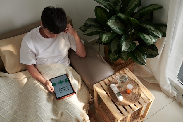 Hombre enfermo leyendo el documento de la póliza de seguro de salud y cómo obtener una compensación por comprar p...