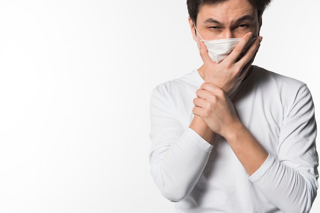 Hombre enfermo tosiendo en máscara médica
