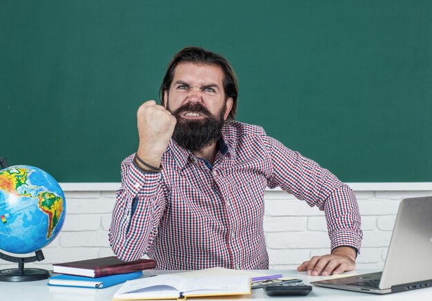 El hombre enojado amenazó con el puño en un ataque de rabia, maestro de escuela.