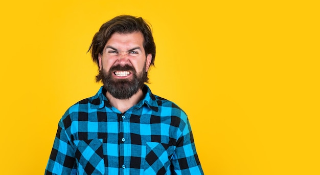 Hombre enojado con barba muestra dientes expresando ira emociones negativas