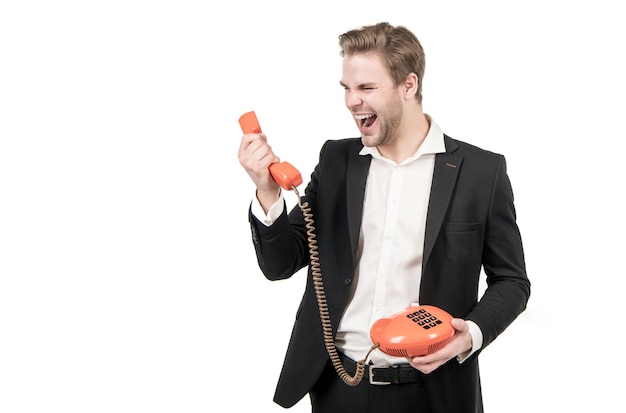 El hombre enojado grita en el receptor de teléfono antiguo que sostiene la telefonía fija anticuada