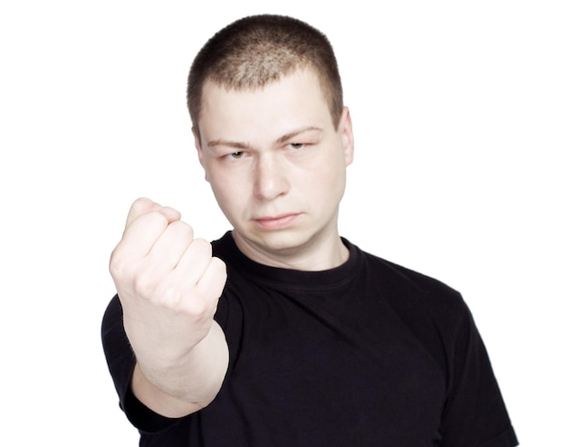 Hombre enojado joven mostrar el puño sobre fondo blanco.