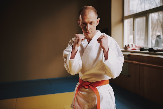 El hombre enseña técnicas de ataques de karate en el pasillo.