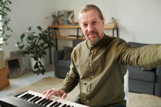 Hombre enseñando a tocar el piano en línea