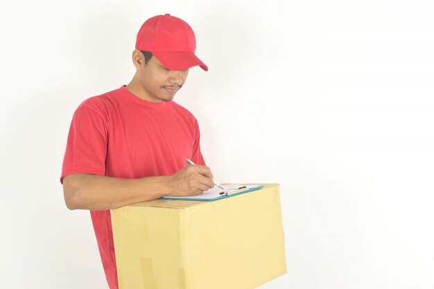 Hombre de entrega con caja y escribir algo en el portapapeles.