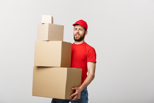 Hombre de entrega haciendo gesto de preocupación con cajas de cartón.