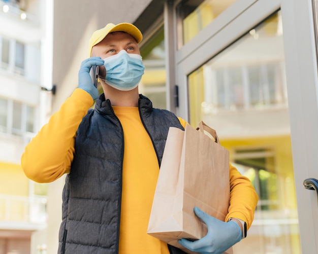 Foto hombre de entrega de tiro medio con bolsa