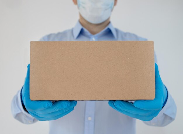 Foto hombre de entregas con cajas de cartón en guantes médicos y máscara protectora compras en línea