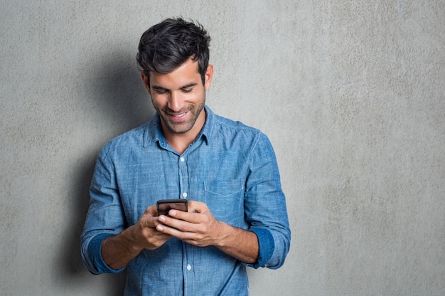 Foto hombre enviando mensajes de texto por teléfono