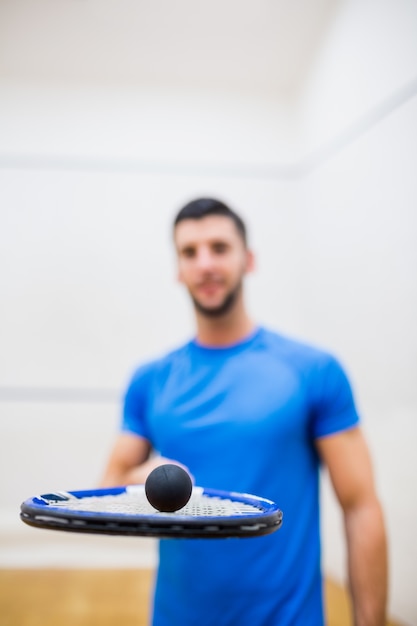 Foto hombre equilibrando una pelota en su raqueta