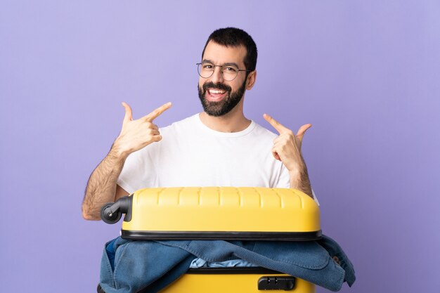 Hombre con equipaje sobre fondo púrpura aislado