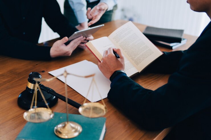 Foto hombre y equipo y abogados de negocios que discuten los papeles del contrato con la escala de cobre amarillo en el escritorio de madera en oficina
