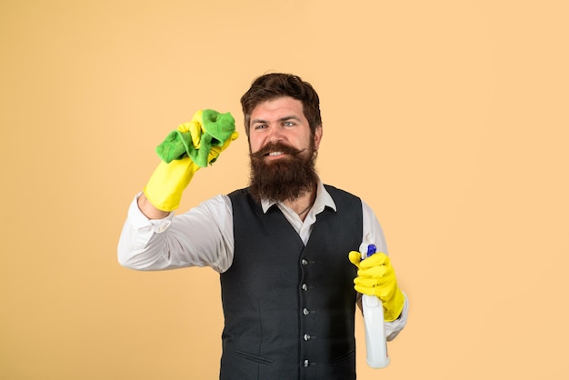 Hombre con equipo de limpieza listo para limpiar ama de llaves en uniforme con spray y trapo masculino