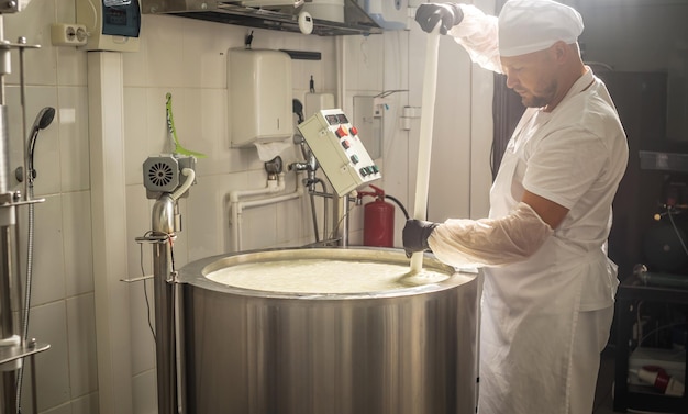 El hombre es un fabricante de queso en el proceso de producción de diferentes variedades de queso en la industria Elaboración de queso de leche