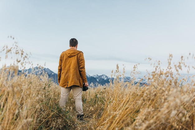 El hombre es un fotógrafo en el campo toma una foto en una vieja cámara de cine retro