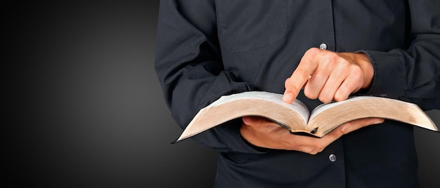 Un hombre es traje de negocios leyendo la Biblia