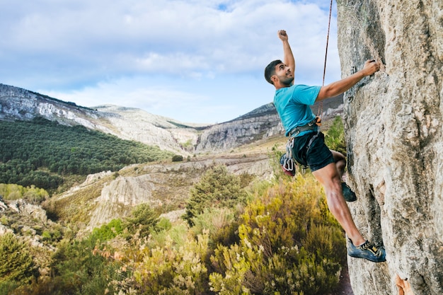 Foto hombre escalando roca en naturaleza