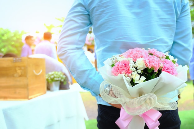 El hombre esconde un ramo de flores