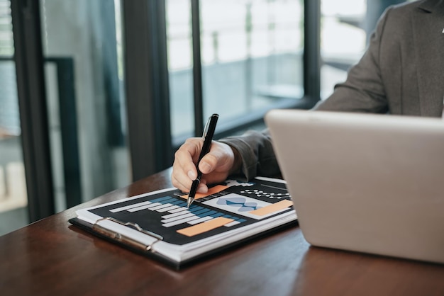 Hombre escribe información empresario trabajando en la computadora portátil escribiendo un plan de negocios mientras está sentado en la oficina.