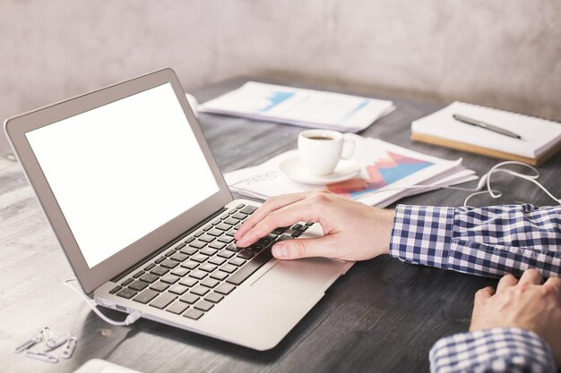Hombre escribiendo en la computadora portátil blanca