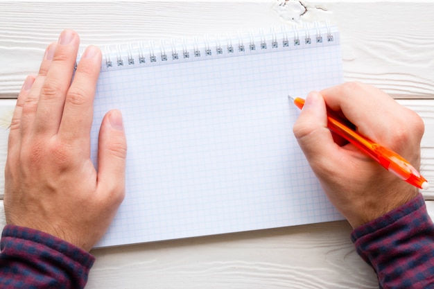 Foto hombre escribiendo en un cuaderno, lugar para texto