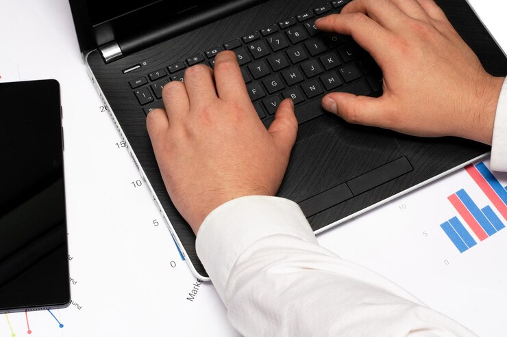 Foto hombre escribiendo en un cuaderno sobre gráficos con datos