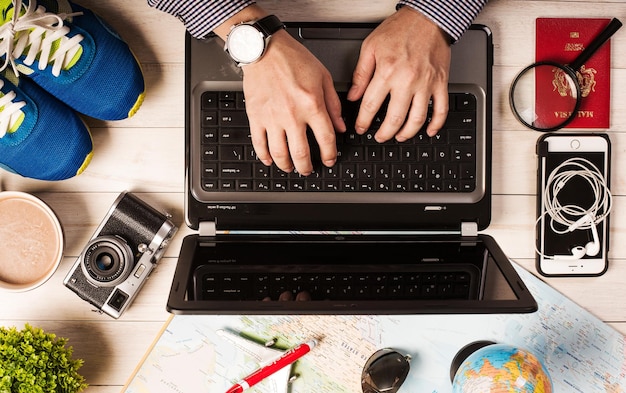 hombre escribiendo en una laptop buscando hotel, planeando vacaciones