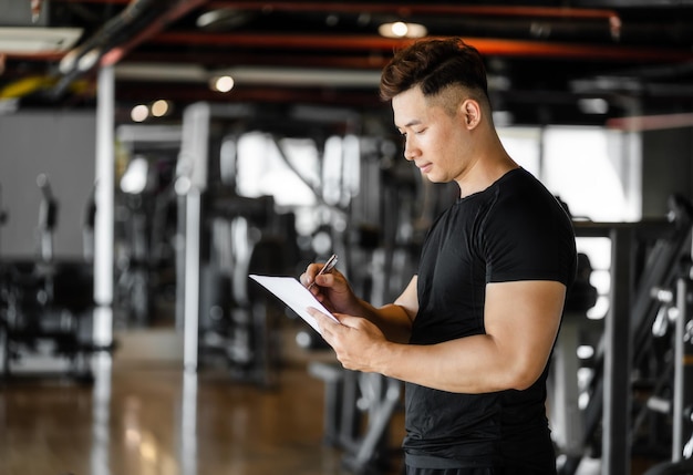 Hombre escribiendo papel en el gimnasio