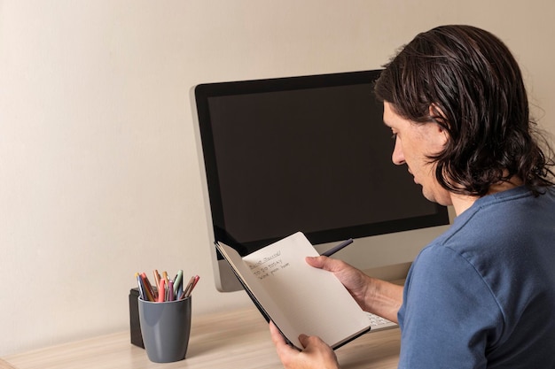 Foto hombre escribiendo en su cuaderno