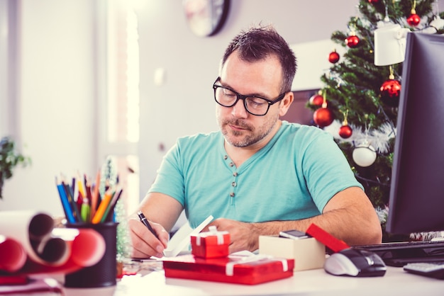 Hombre escribiendo una tarjeta de navidad