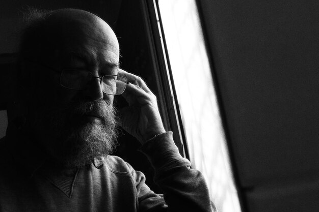 Foto hombre escuchando canciones mientras está sentado junto a la ventana